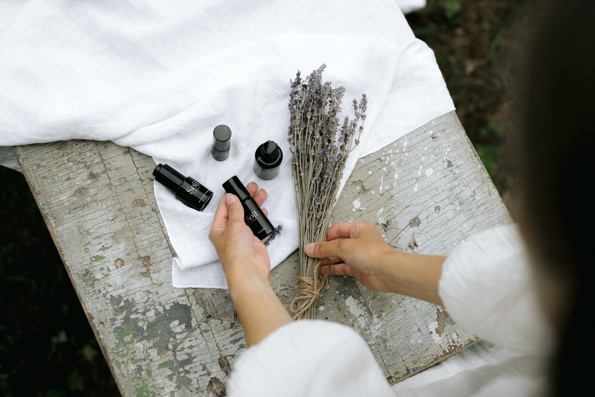 Henna Uusikallio Soil of Beautyn perustaja ja tuotteita vanhalla pöydällä